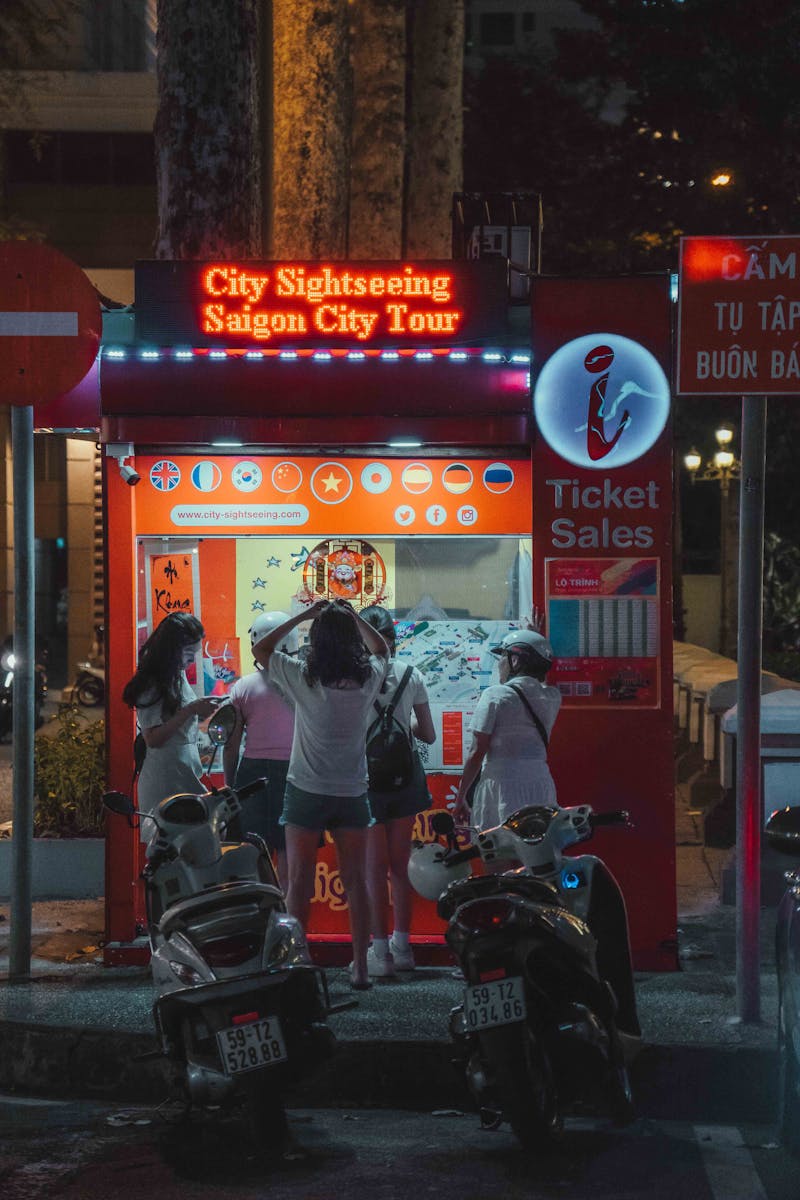 Photo by Khanh Nguyen People standing in front of a food stand at night